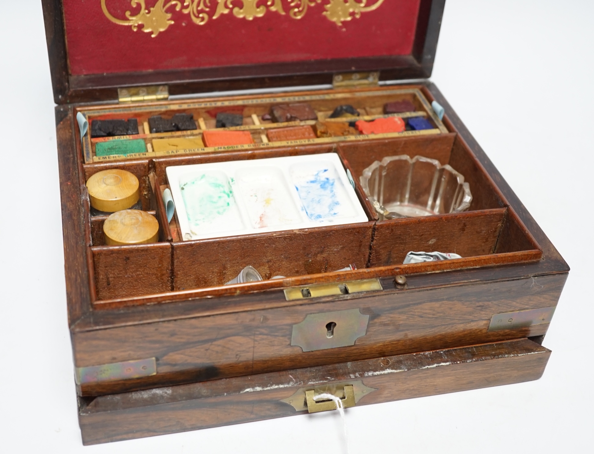 An Edwardian G Rowney & Co brass mounted artist’s paint box with watercolour blocks, tubes and charcoal sticks